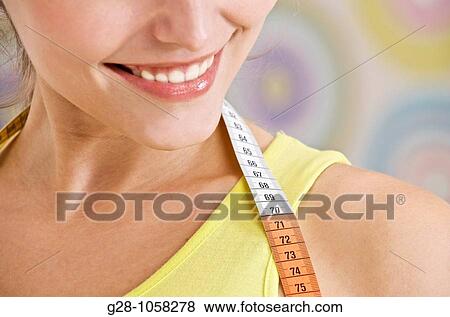 happy young woman in a yellow top, with a measuring tape around her neck, close up View Large Photo Image Stock Photo - happy young woman in a yellow top, with a measuring tape around her neck, close up. Fotosearch