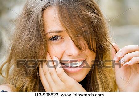 Happy young woman portrait with one eye peeking behind hair View Large Photo Image Stock Image - Happy young woman portrait with one eye peeking behind hair. Fotosearch