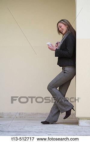 Happy young woman standing and taking notes View Large Photo Image Stock Photo - Happy young woman standing and taking notes. Fotosearch