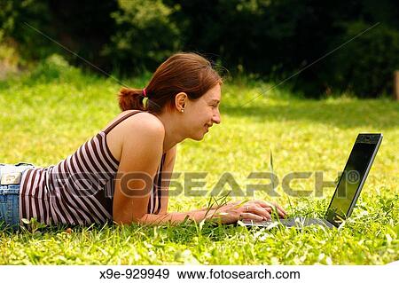 Happy young woman using her laptop outdoors View Large Photo Image Stock Photo - Happy young woman using her laptop outdoors. Fotosearch