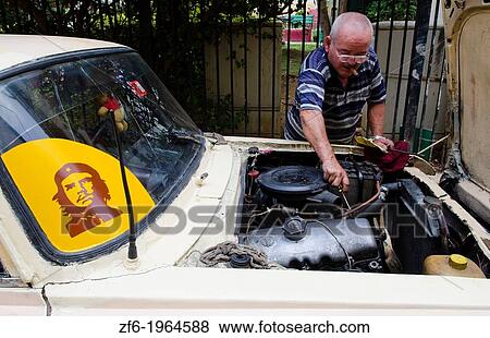 Havana Cuba typical scene in Cuba of man repairing old car on street with Che sticker on windshield. View Large Photo Image Stock Photo - Havana Cuba typical scene in Cuba of man repairing old car on street with Che sticker on windshield.. Fotosearch