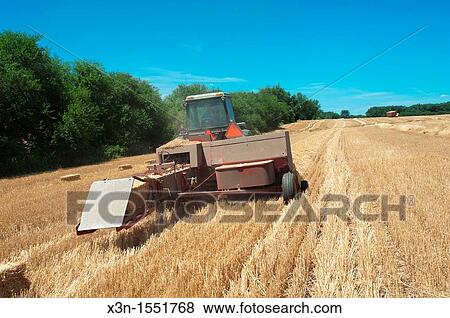 Hay baler working in field View Large Photo Image Stock Photo - Hay baler working in field. Fotosearch