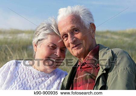 Head and shoulder photograph of elderly caucasian couple leading head to head at eachother and looking into the camera with the dunes and blue sky in the background, Island of Amrum, Northfrisian, Schleswig_Holstein, Northern Germany, Europe View Large Photo Image Stock Photography - Head and shoulder photograph of elderly caucasian couple leading head to head at eachother and looking into the camera with the dunes and blue sky in the background, Island of Amrum, Northfrisian, Schleswig_Holstein, Northern Germany, Europe. Fotosearch