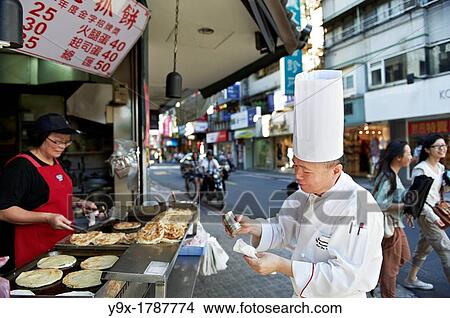 Head Chef Huang Lai Fa of The Grand Formosa Regent Hotel Taipei, posing and sampling food on Yongkang Street in Taipei, Taiwan View Large Photo Image Picture - Head Chef Huang Lai Fa of The Grand Formosa Regent Hotel Taipei, posing and sampling food on Yongkang Street in Taipei, Taiwan. Fotosearch