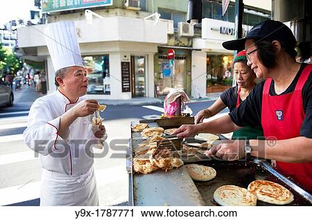 Head Chef Huang Lai Fa of The Grand Formosa Regent Hotel Taipei, posing and sampling food on Yongkang Street in Taipei, Taiwan View Large Photo Image Stock Image - Head Chef Huang Lai Fa of The Grand Formosa Regent Hotel Taipei, posing and sampling food on Yongkang Street in Taipei, Taiwan. Fotosearch