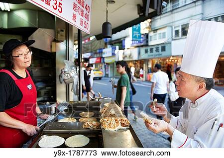 Head Chef Huang Lai Fa of The Grand Formosa Regent Hotel Taipei, posing and sampling food on Yongkang Street in Taipei, Taiwan View Large Photo Image Stock Image - Head Chef Huang Lai Fa of The Grand Formosa Regent Hotel Taipei, posing and sampling food on Yongkang Street in Taipei, Taiwan. Fotosearch