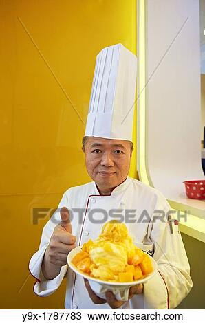 Head Chef Huang Lai Fa of The Grand Formosa Regent Hotel Taipei, posing and sampling food on Yongkang Street in Taipei, Taiwan View Large Photo Image Stock Image - Head Chef Huang Lai Fa of The Grand Formosa Regent Hotel Taipei, posing and sampling food on Yongkang Street in Taipei, Taiwan. Fotosearch