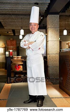 Stock Photo - Head Chef Huang Lai Fa of The Grand Formosa Regent Hotel Taipei, posing and sampling food on Yongkang Street in Taipei, Taiwan. Fotosearch
