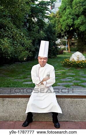 Stock Photo - Head Chef Huang Lai Fa of The Grand Formosa Regent Hotel Taipei, posing and sampling food on Yongkang Street in Taipei, Taiwan. Fotosearch