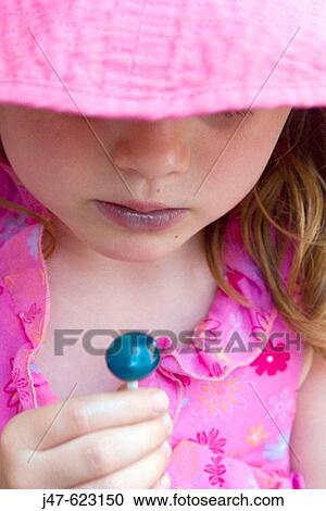 Headshot, 4 year old girl looking at a blue lolly View Large Photo Image Stock Image - Headshot, 4 year old girl looking at a blue lolly. Fotosearch