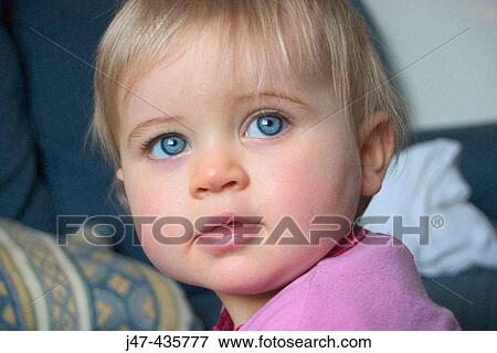 Stock Photo - Headshot of a 1 year old baby, looking off camera, big bright blue eyes. Fotosearch