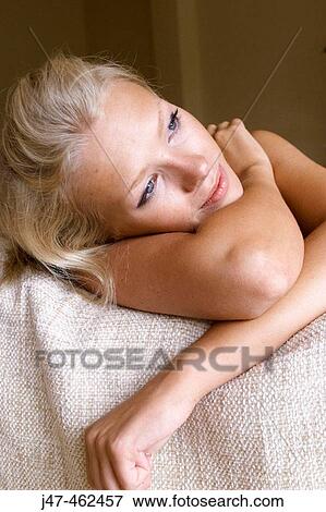 Headshot of a 21 year old girl sitting on the sofa leaning on the back looking happy View Large Photo Image Stock Photo - Headshot of a 21 year old girl sitting on the sofa leaning on the back looking happy. Fotosearch