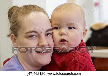 Stock Image - Headshot of a 34 year old mother with her 1 year old baby boy. Fotosearch