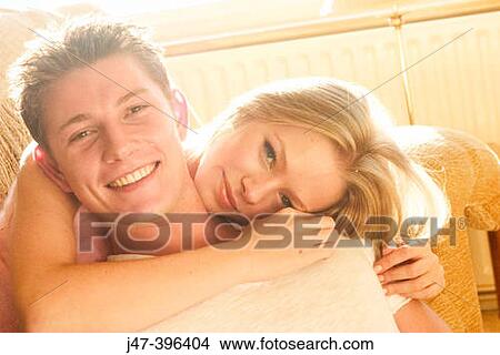 Headshot of a young couple sitting together smiling into camera View Large Photo Image Picture - Headshot of a young couple sitting together smiling into camera. Fotosearch