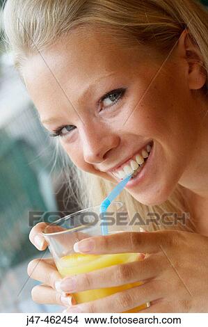 headshot of a21 year old girl sitting in a cafe drinking orange juice, smiling into camera View Large Photo Image Picture - headshot of a21 year old girl sitting in a cafe drinking orange juice, smiling into camera. Fotosearch