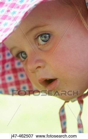 Headshot of an 18 month old girl wearing a big floppy sunhat View Large Photo Image Stock Photo - Headshot of an 18 month old girl wearing a big floppy sunhat. Fotosearch