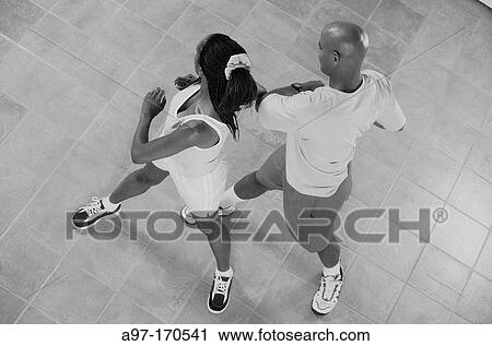 Stock Image - Healthy Afro-American man and woman exercise. Fotosearch