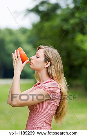 Healthy blonde woman enjoying a soup in the park View Large Photo Image Stock Photo - Healthy blonde woman enjoying a soup in the park. Fotosearch