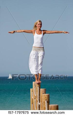 Healthy young woman balancing on a wooden post View Large Photo Image Stock Photography - Healthy young woman balancing on a wooden post. Fotosearch