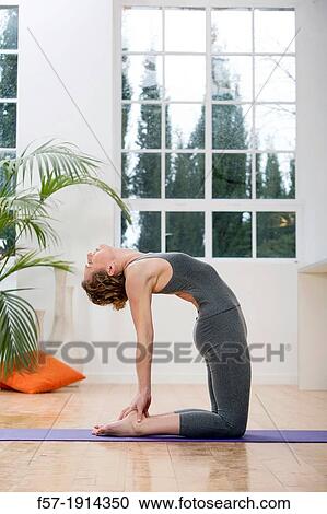 Healthy young woman doing the camel pose yoga position View Large Photo Image Stock Image - Healthy young woman doing the camel pose yoga position. Fotosearch