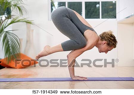 Healthy young woman doing the crane pose yoga position View Large Photo Image Stock Photo - Healthy young woman doing the crane pose yoga position. Fotosearch