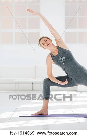 Stock Photo - Healthy young woman doing the extended pose yoga position. Fotosearch