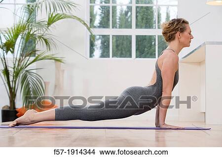 Healthy young woman doing the upward-facing dog yoga position View Large Photo Image Picture - Healthy young woman doing the upward-facing dog yoga position. Fotosearch