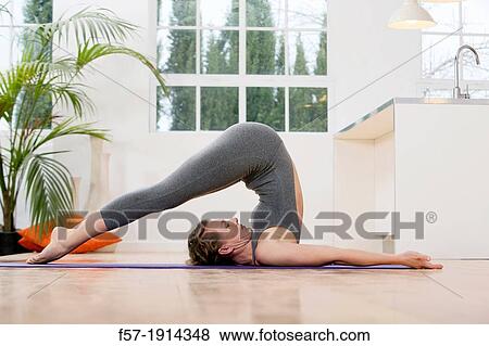 Healthy young woman doing the plow pose yoga position View Large Photo Image Stock Photo - Healthy young woman doing the plow pose yoga position. Fotosearch
