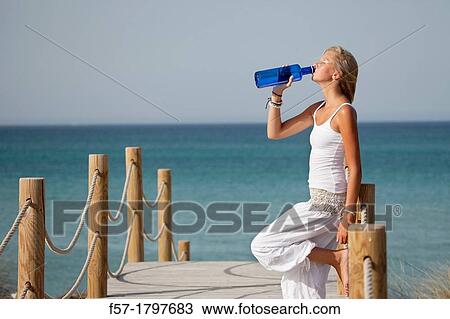 Healthy young woman drinking mineral water View Large Photo Image Stock Image - Healthy young woman drinking mineral water. Fotosearch