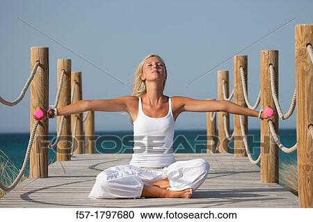 Healthy young woman exercising on a boardwalk View Large Photo Image Stock Image - Healthy young woman exercising on a boardwalk. Fotosearch
