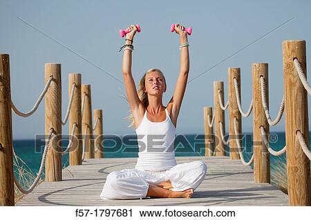 Healthy young woman exercising on a boardwalk View Large Photo Image Stock Image - Healthy young woman exercising on a boardwalk. Fotosearch