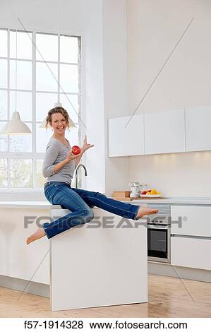 Stock Photo - Healthy young woman in her kitchen. Fotosearch