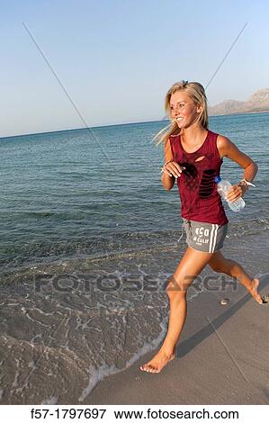 Healthy young woman jogging on the beach View Large Photo Image Stock Photo - Healthy young woman jogging on the beach. Fotosearch