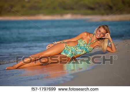 Healthy young woman lying on the shoreline View Large Photo Image Stock Photo - Healthy young woman lying on the shoreline. Fotosearch