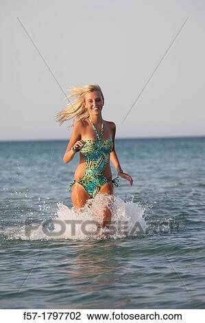 Healthy young woman running out of the sea View Large Photo Image Stock Image - Healthy young woman running out of the sea. Fotosearch