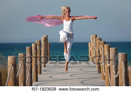 Healthy young woman skipping down a boardwalk View Large Photo Image Stock Photo - Healthy young woman skipping down a boardwalk. Fotosearch