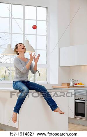 Healthy young woman throwing an apple into the air View Large Photo Image Stock Photo - Healthy young woman throwing an apple into the air. Fotosearch