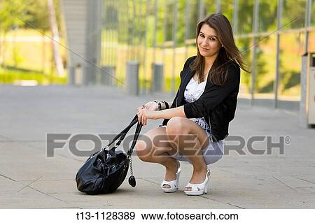 Heavy handbag, young woman in squatting View Large Photo Image Stock Photo - Heavy handbag, young woman in squatting. Fotosearch