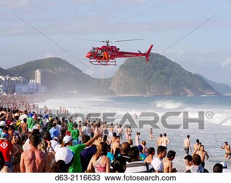 Stock Image - Helicopter rescuing people from the rough seas of Copacabana Beach.. Fotosearch