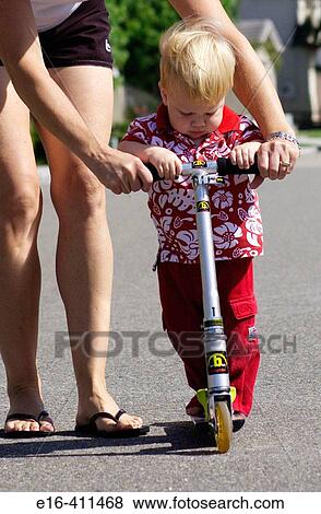 her helping toddler with scooter View Large Photo Image Stock Photo - her helping toddler with scooter. Fotosearch