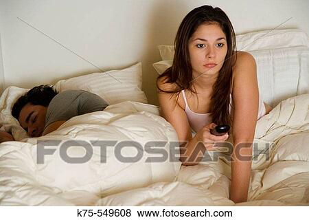he's asleep, she's got the remote View Large Photo Image Stock Photo - he's asleep, she's got the remote. Fotosearch