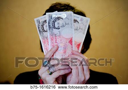 Stock Photograph - hidden behind pounds sterling. Fotosearch