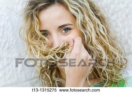 Stock Photography - Hiding her face with curly hair young woman. Fotosearch