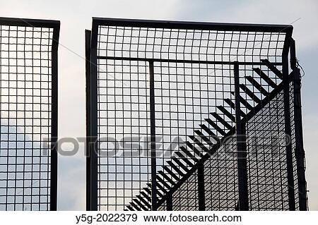 high metal fence against sky View Large Photo Image Stock Photo - high metal fence against sky. Fotosearch