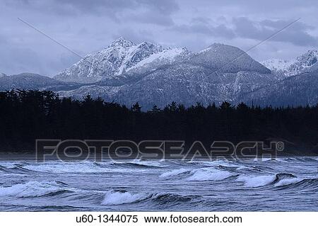 Stock Photography - High seas and snow-capped mountains make up the landscape at Tofino, British Columbia, Canada. Fotosearch