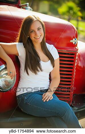 Highschool senior, female caucasian, 17 years old, posing sitting on bumber of oldtimer truck View Large Photo Image Picture - Highschool senior, female caucasian, 17 years old, posing sitting on bumber of oldtimer truck. Fotosearch