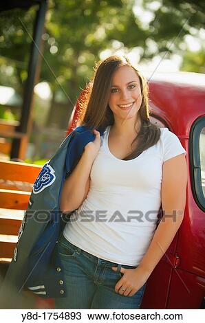 Highschool senior, female caucasian, 17 years old, posing with her school letterman jacket next to vintage automobile View Large Photo Image Stock Image - Highschool senior, female caucasian, 17 years old, posing with her school letterman jacket next to vintage automobile. Fotosearch