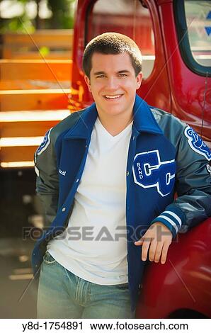 Highschool senior, male caucasian, 17 years old, posing with his school letterman jacket next to vintage automobile View Large Photo Image Stock Image - Highschool senior, male caucasian, 17 years old, posing with his school letterman jacket next to vintage automobile. Fotosearch
