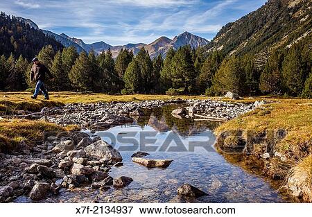 Stock Photo - Hiker. Aig? estortes area, Aig? estortes i Estany de Sant Maurici National Park, Pyrenees, Lleida province, Catalonia, Spain.. Fotosearch