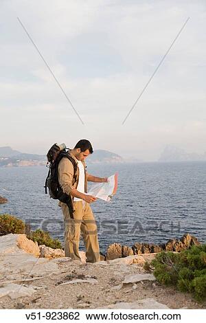 Stock Image - Hiker cheking his map in Ibiza, Spain. Fotosearch